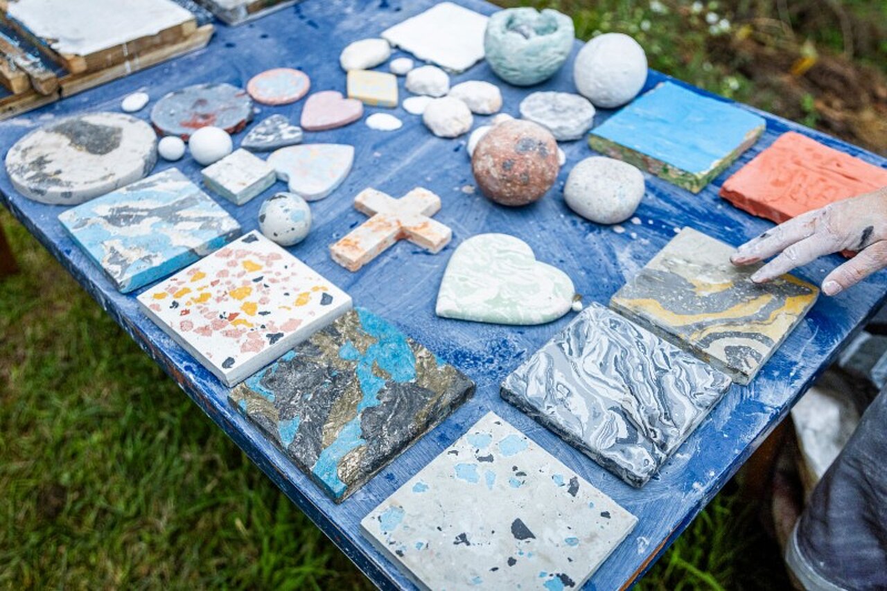 Unterschiedliche Kreationen aus Stuckmarmor auf einem blauen Tisch.