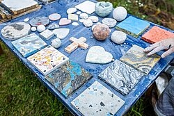 Unterschiedliche Kreationen aus Stuckmarmor auf einem blauen Tisch.